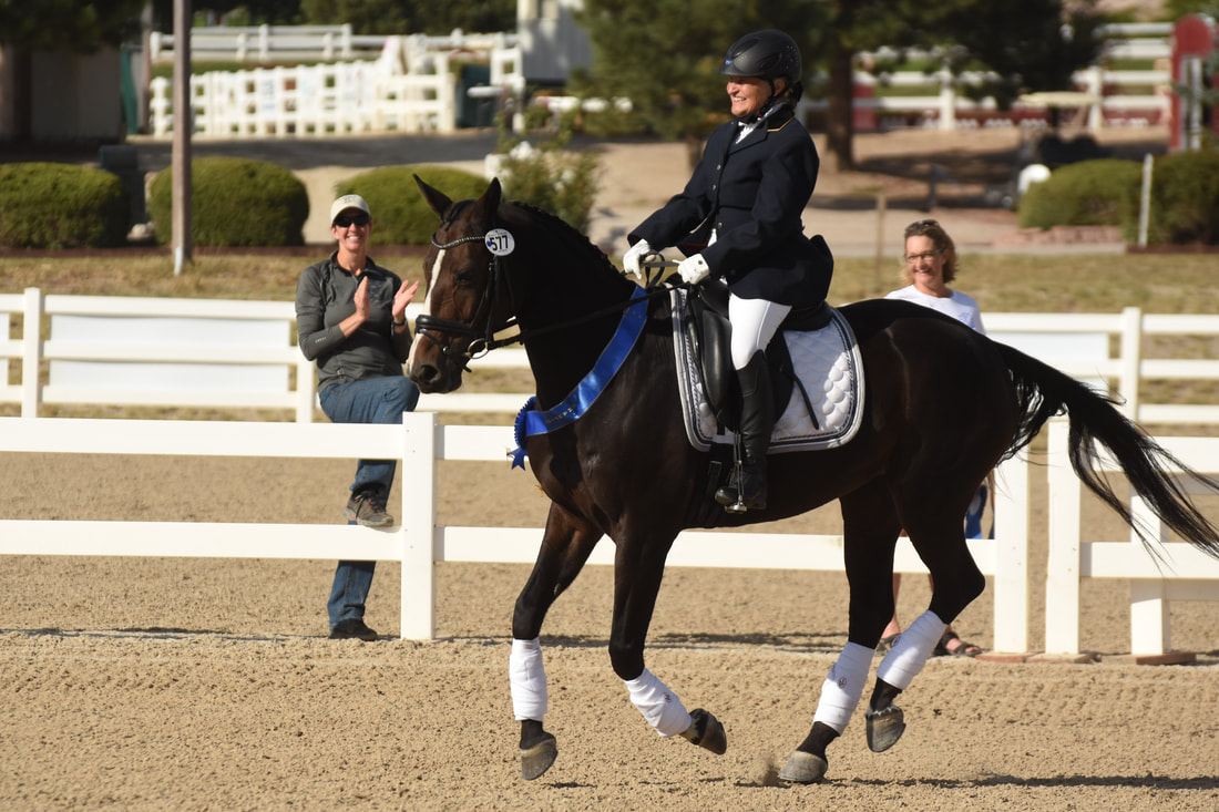 Author M.J. Evans and her horse competing in Dressage